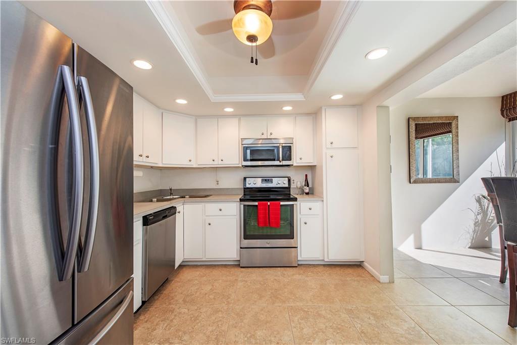 214 Bobolink Way, Unit 214B Naples, FL 34105 - Photo 6 of 12 a kitchen with stainless steel appliances granite countertop a refrigerator stove and sink