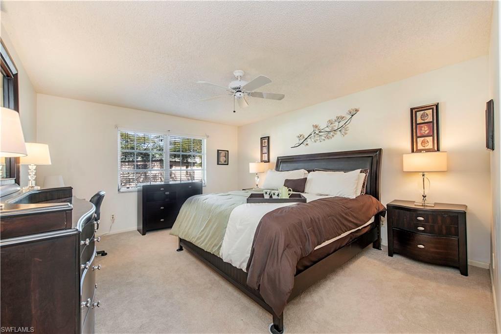 214 Bobolink Way, Unit 214B Naples, FL 34105 - Photo 8 of 12 a bedroom with a bed and a window