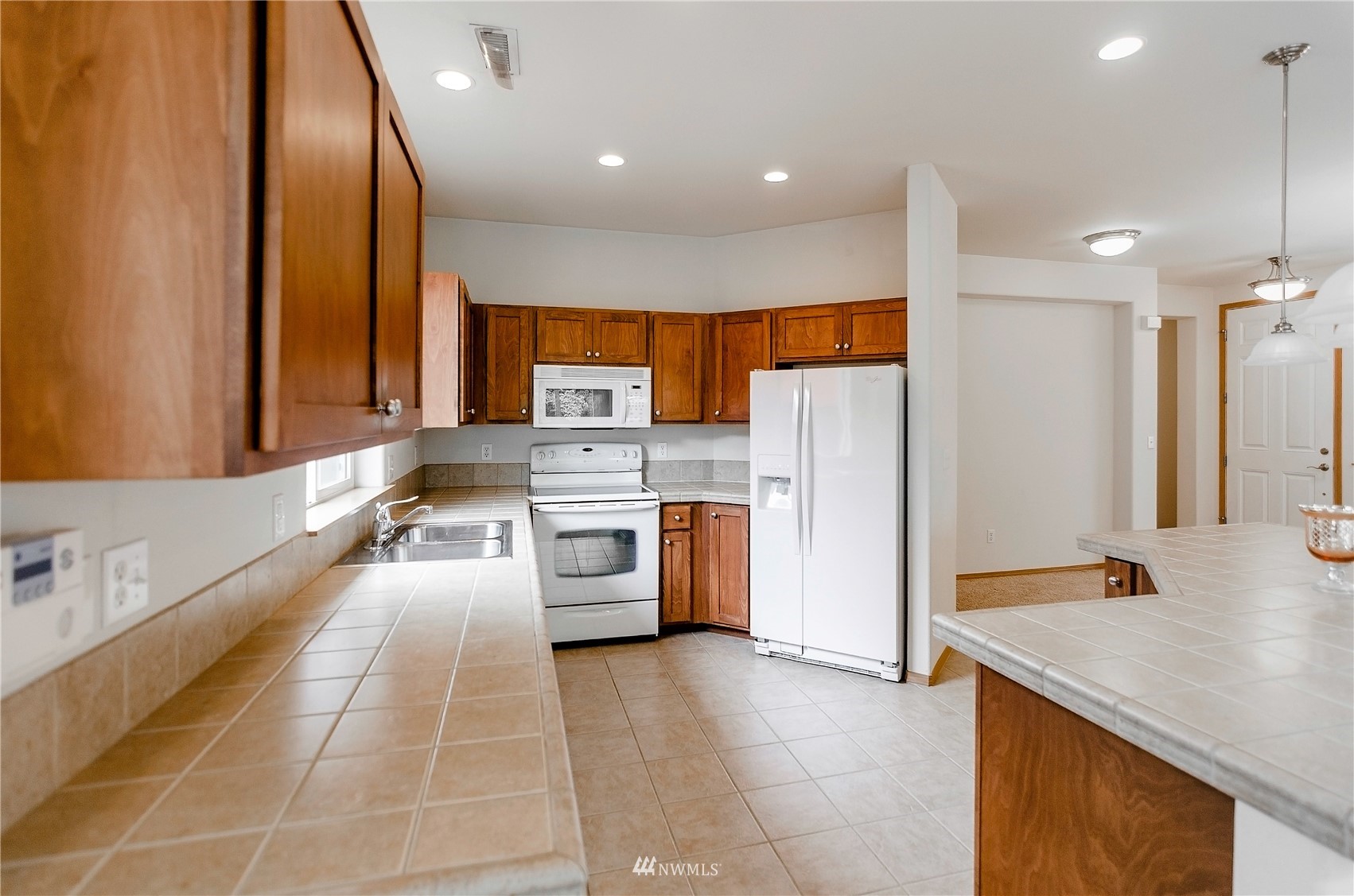 8228 Bainbridge Loop Northeast Lacey, WA 98516 - Photo 13 of 32 a kitchen with stainless steel appliances a stove a sink a refrigerator and a oven