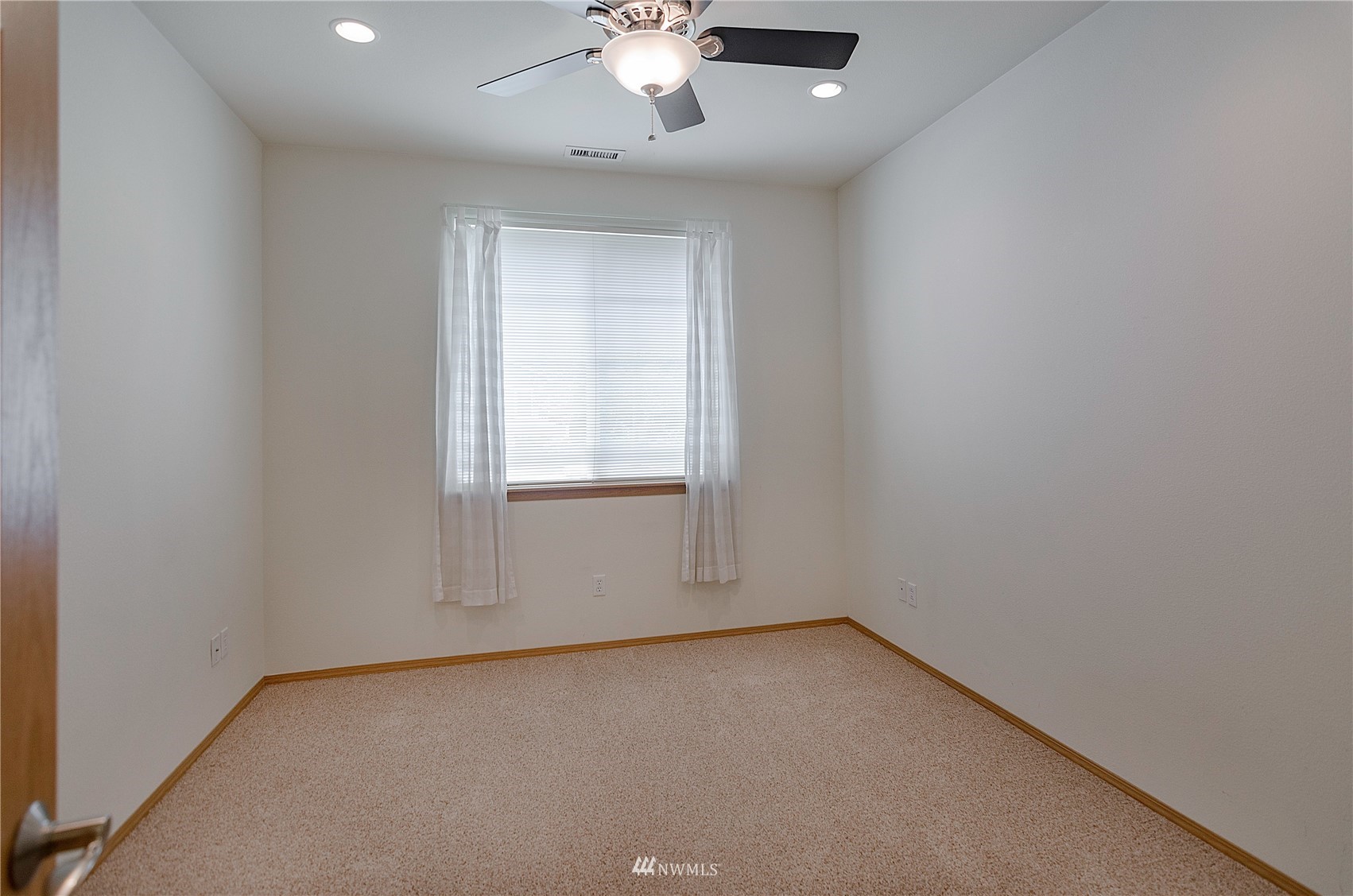 8228 Bainbridge Loop Northeast Lacey, WA 98516 - Photo 20 of 32 an empty room with a chandelier fan and windows