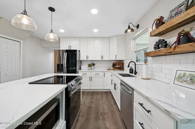 a spacious bedroom with a bed and a chandelier