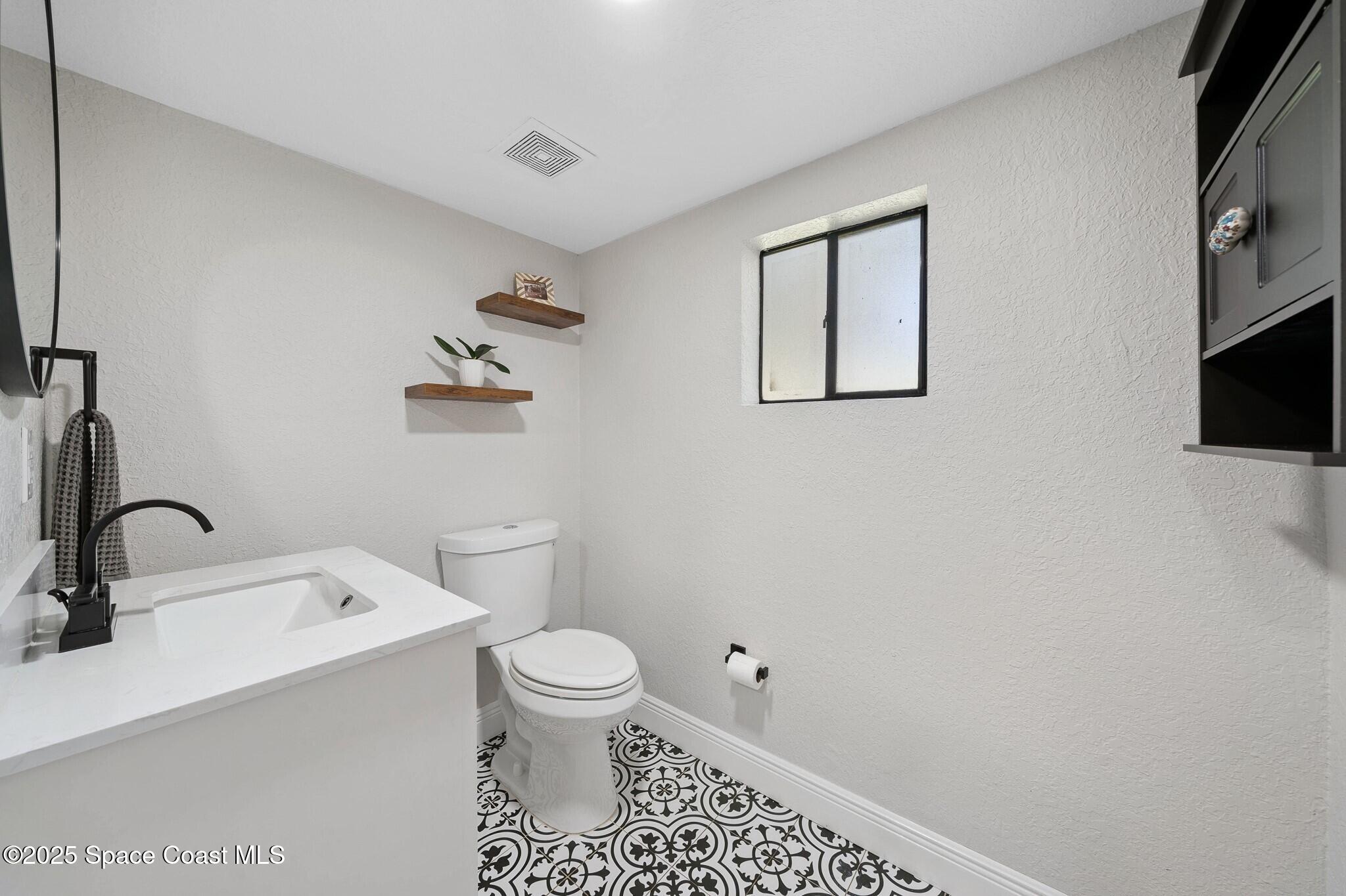 1325 Friday Road Cocoa, FL 32926 - Photo 16 of 59 a bathroom with a toilet sink and mirror