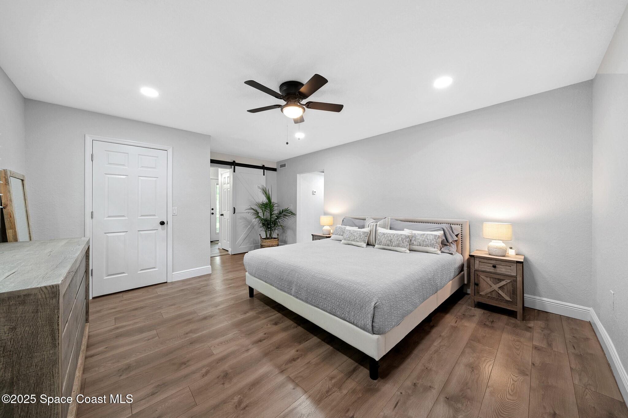 1325 Friday Road Cocoa, FL 32926 - Photo 17 of 59 a spacious bedroom with a bed and a chandelier