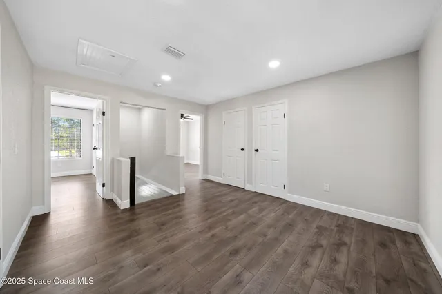 a bedroom with a large bed and a flat tv screen
