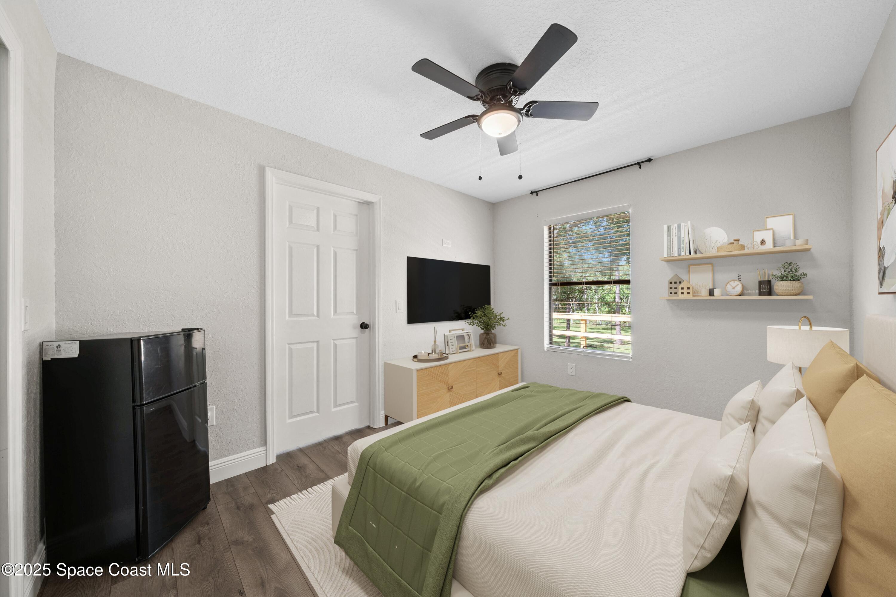 1325 Friday Road Cocoa, FL 32926 - Photo 31 of 59 a bedroom with a large bed and a flat tv screen