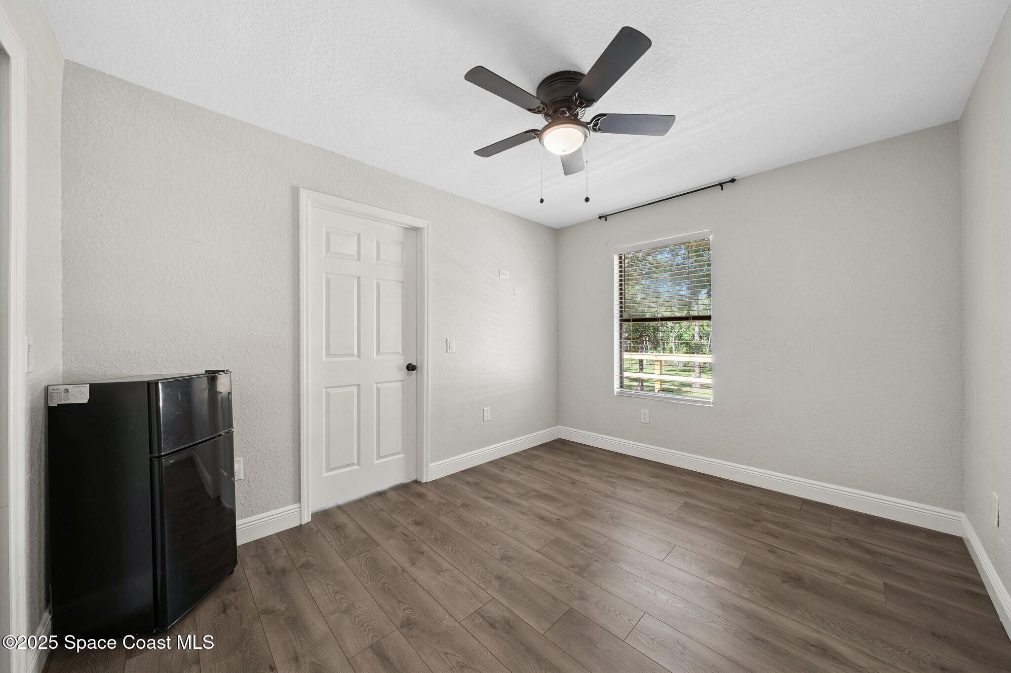 1325 Friday Road Cocoa, FL 32926 - Photo 32 of 59 wooden floor in an empty room with a window