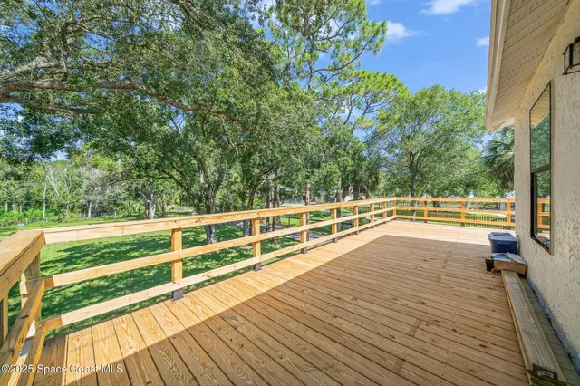 a view of house with swimming pool and a yard