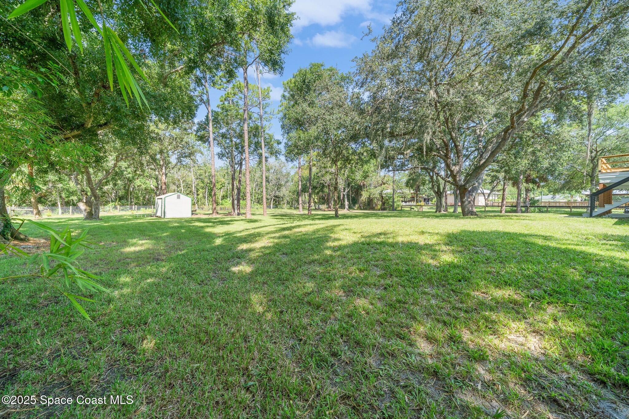 1325 Friday Road Cocoa, FL 32926 - Photo 44 of 59 a big yard with lots of green space and trees in the back