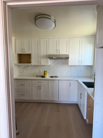 a kitchen with granite countertop white cabinets and stainless steel appliances