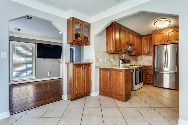 a kitchen with stainless steel appliances granite countertop a refrigerator a stove and a sink