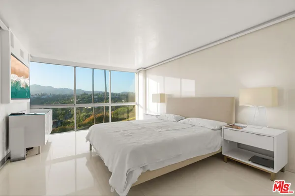 a bedroom with a bed and a large window