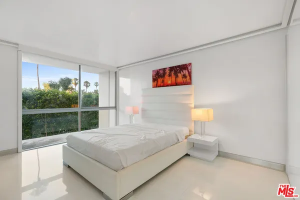 a bedroom with a bed and a large window