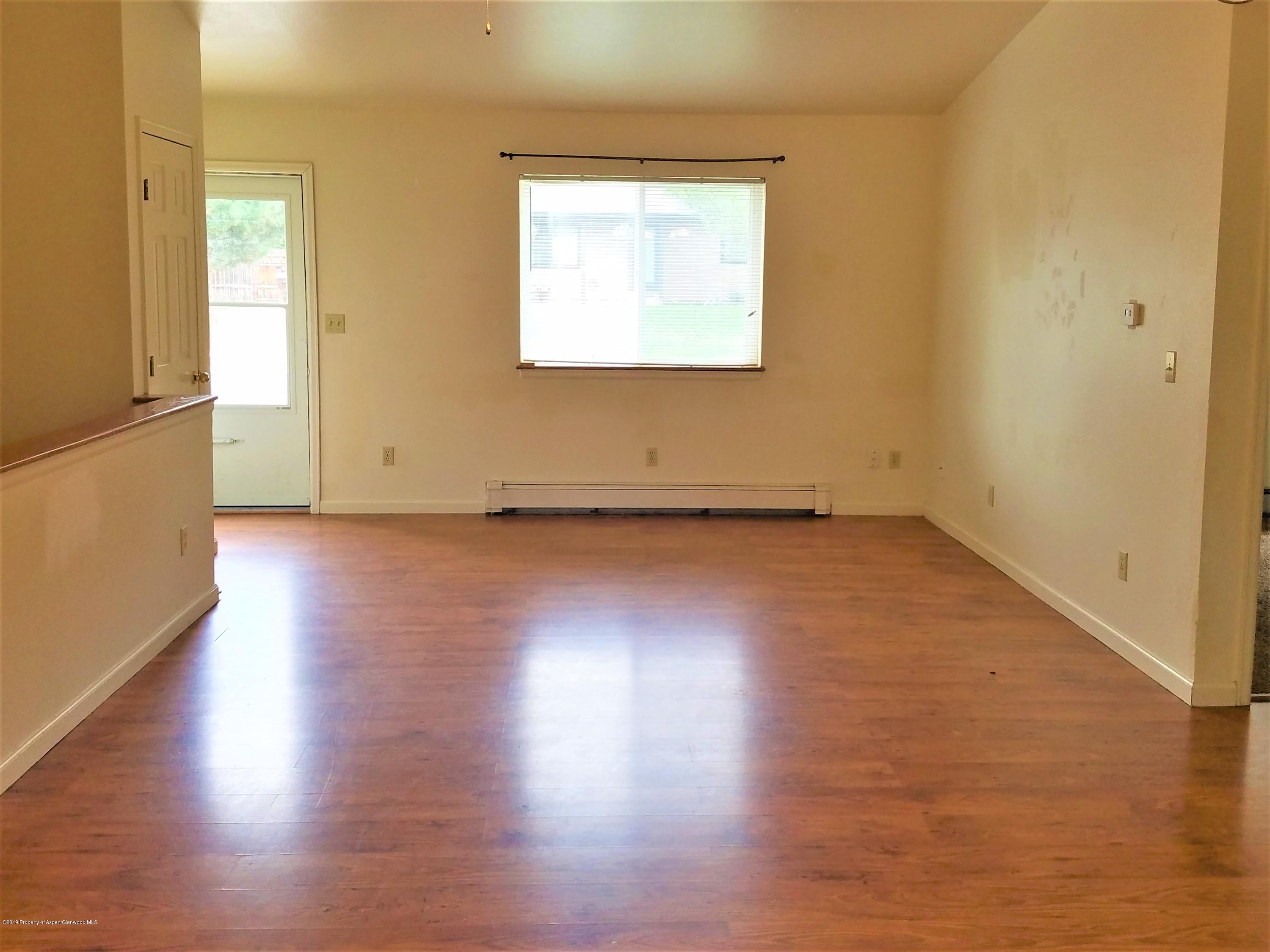 1526 Arabian Avenue Rifle, CO 81650 - Photo 5 of 20 an empty room with wooden floor and windows