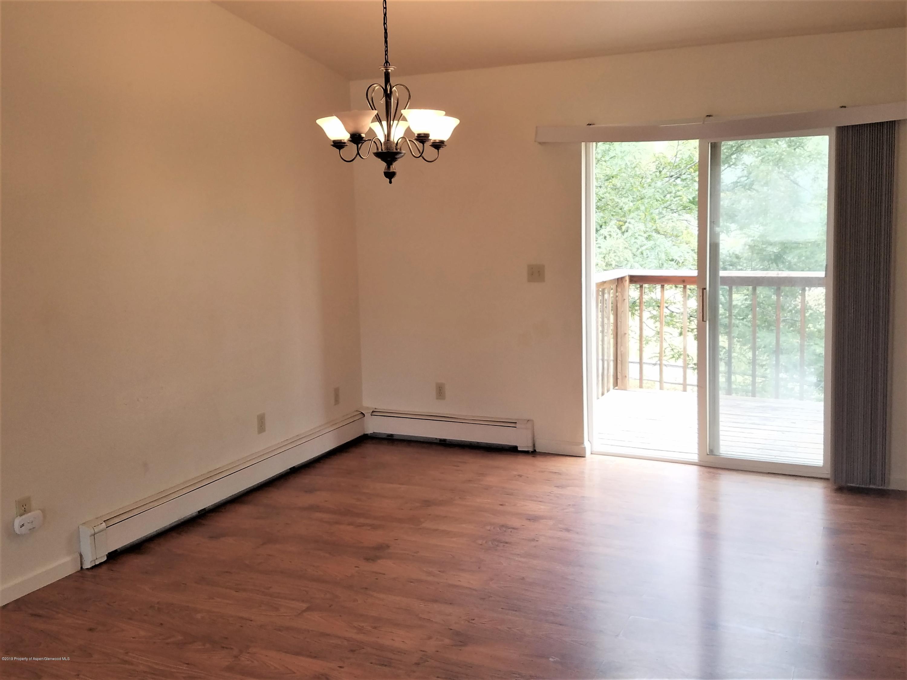 1526 Arabian Avenue Rifle, CO 81650 - Photo 6 of 20 a view of an empty room with wooden floor and a window