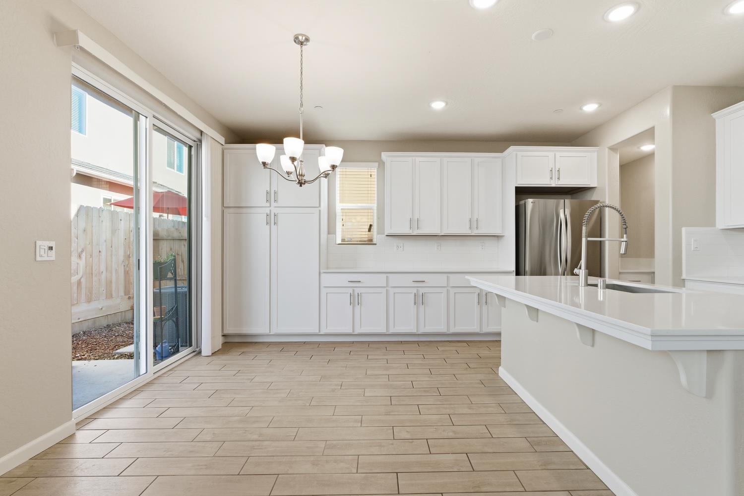 1107 Significant Way West Madera, CA 93636 - Photo 12 of 42 a large kitchen with granite countertop a stove a sink a refrigerator and a granite counter top