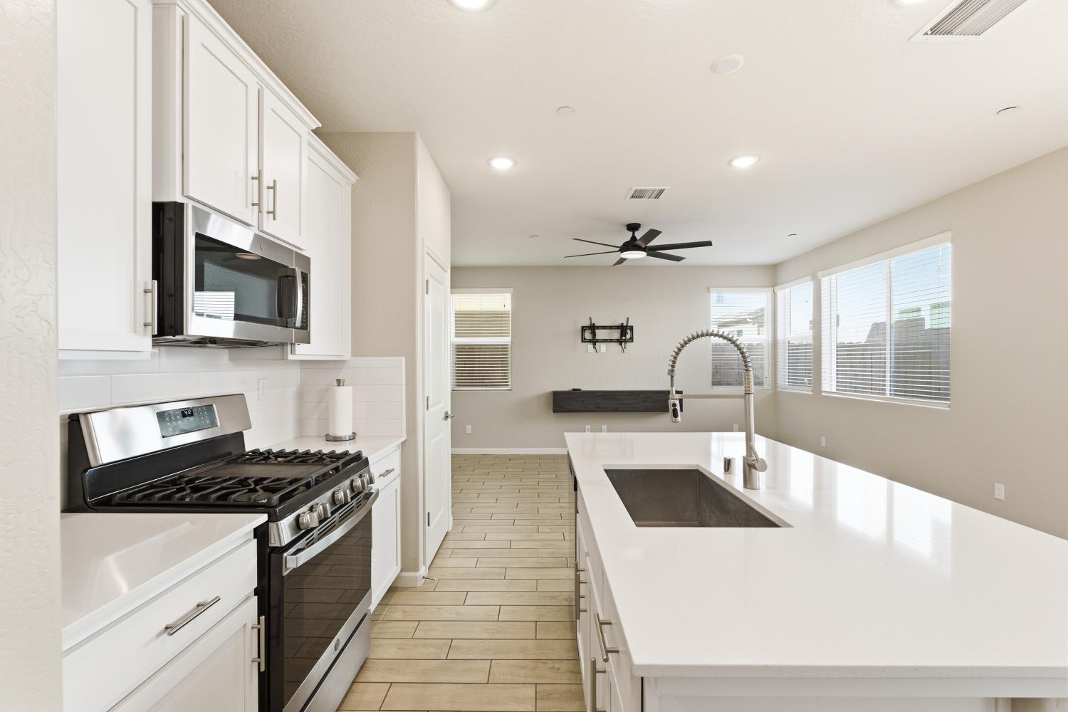 1107 Significant Way West Madera, CA 93636 - Photo 19 of 42 a kitchen with a sink a stove and cabinets