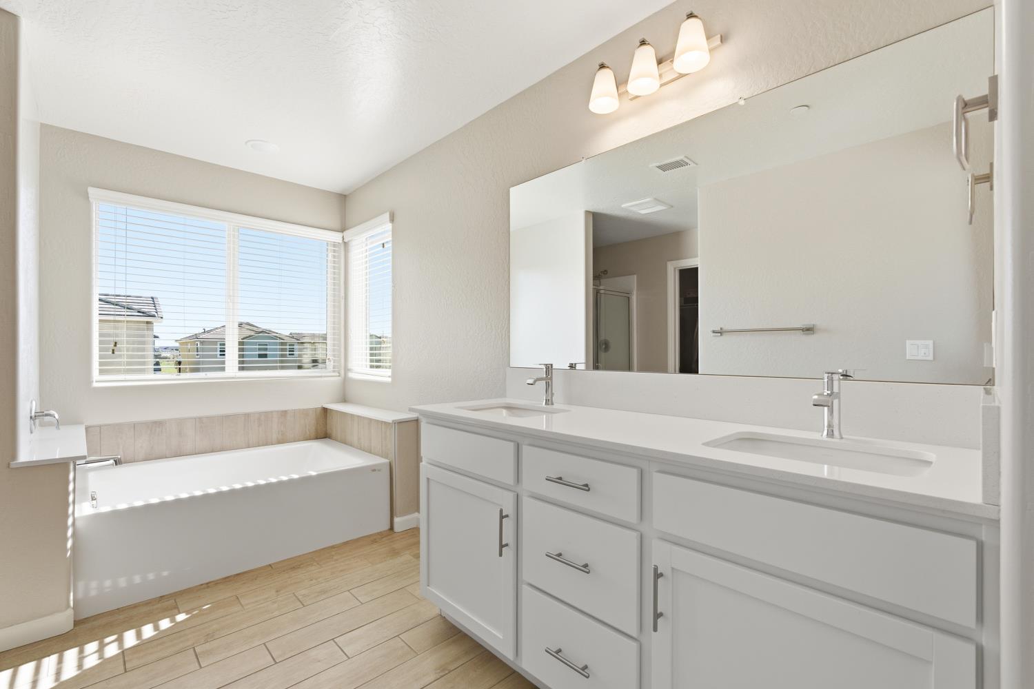 1107 Significant Way West Madera, CA 93636 - Photo 27 of 42 a bathroom with a tub a sink double vanity and a mirror