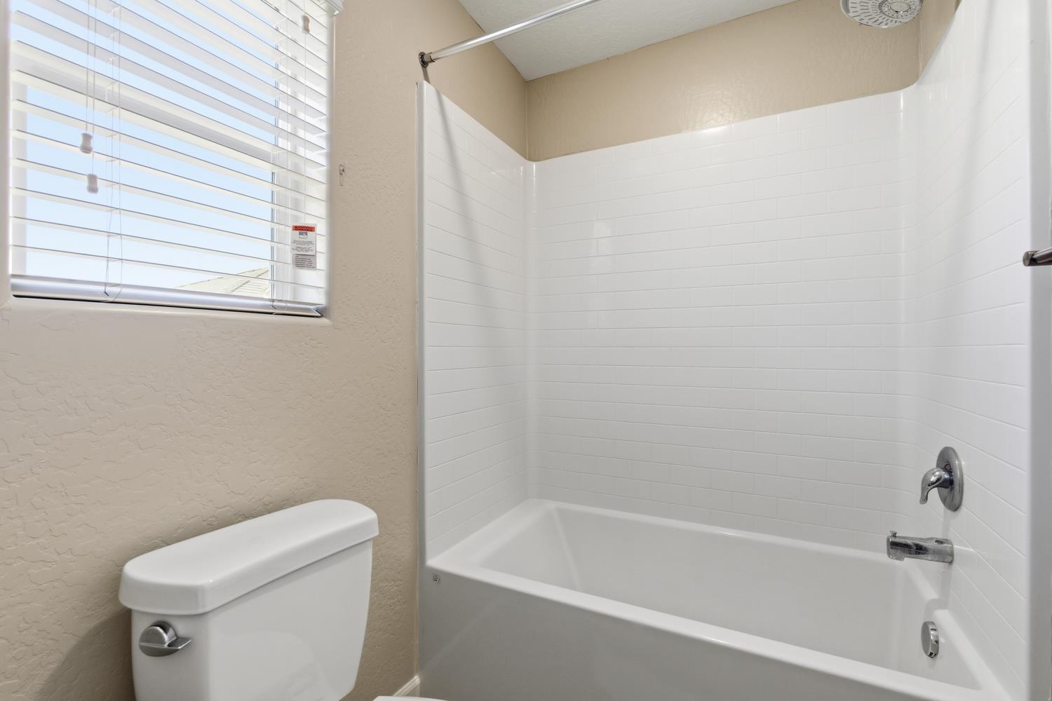 1107 Significant Way West Madera, CA 93636 - Photo 31 of 42 a white bath tub sitting next to a white toilet and a sink