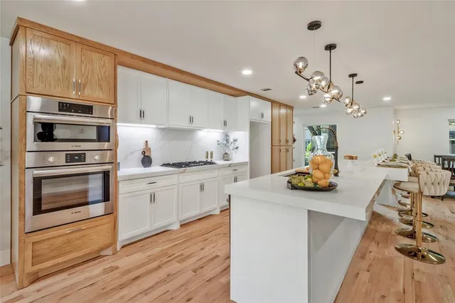 a living room with furniture a wooden floor and a kitchen view