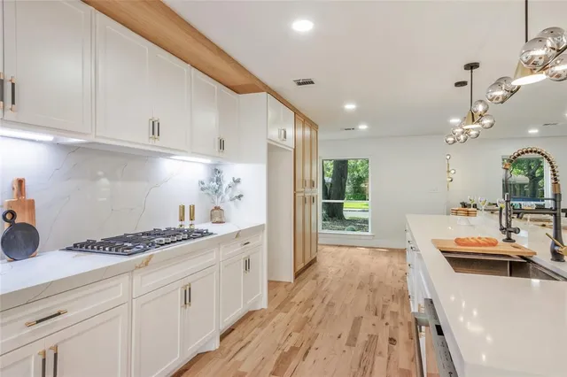 a kitchen with sink refrigerator and cabinets