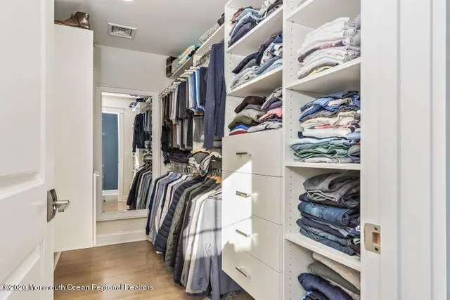 a view of walk in closet with clothes and shoes