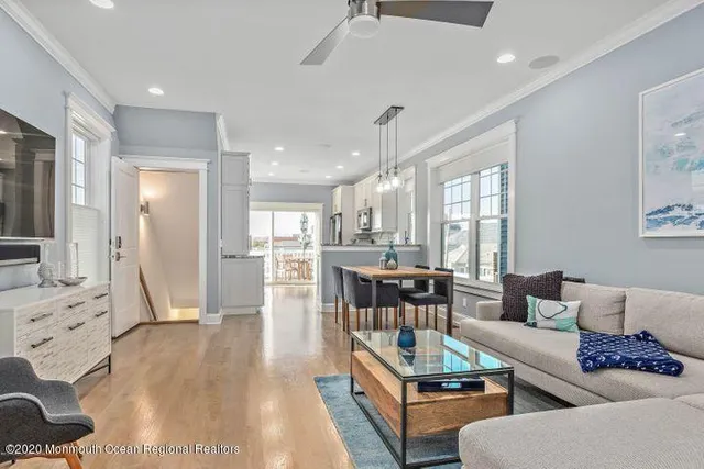 a living room with furniture wooden floor and a large window