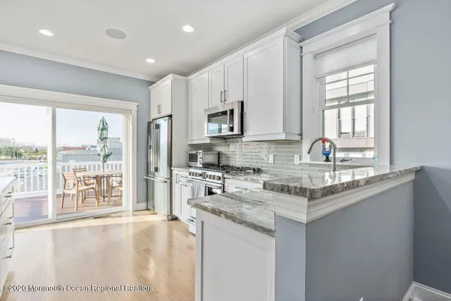 a kitchen with stainless steel appliances granite countertop a stove a sink and a refrigerator