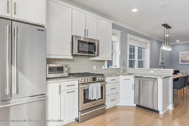 a kitchen with stainless steel appliances granite countertop a stove top oven a sink dishwasher and a microwave oven with cabinets