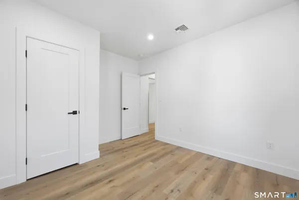 a view of a big room with wooden floor and windows