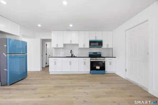 a kitchen with stainless steel appliances granite countertop a stove a sink and a refrigerator