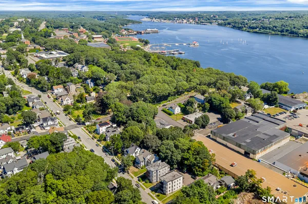 an aerial view of residential houses with outdoor space and trees