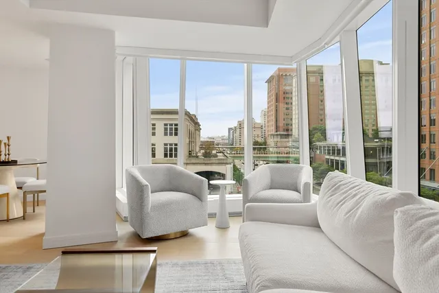 a living room with furniture and floor to ceiling windows