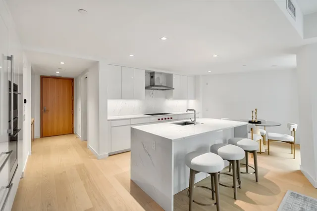 a kitchen with kitchen island cabinets and chairs in it