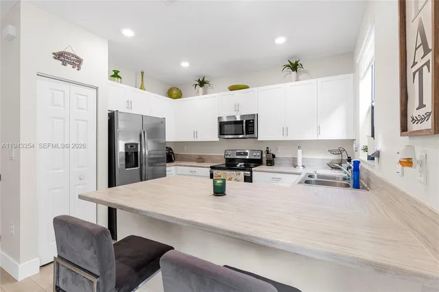 a kitchen with a sink stainless steel appliances and white cabinets
