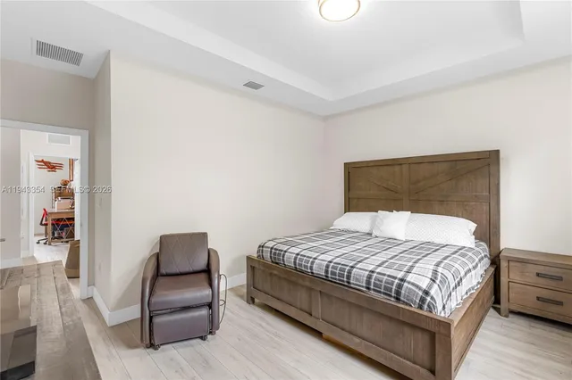 a large bed sitting in a bedroom next to a lamp with a table and chair