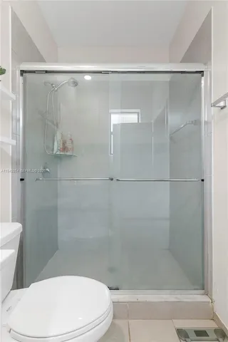 a white toilet and shower in a bathroom