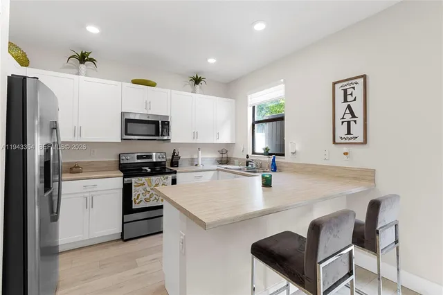 a kitchen with white cabinets and stainless steel appliances