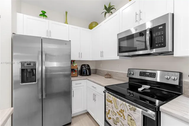 a kitchen with stainless steel appliances granite countertop a stove a refrigerator and a microwave