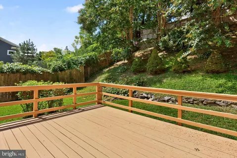 a view of outdoor space and deck with wooden fence