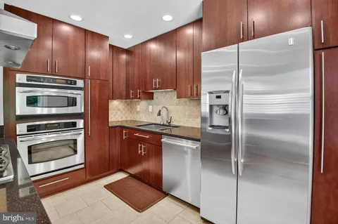a kitchen with stainless steel appliances granite countertop a refrigerator and a sink
