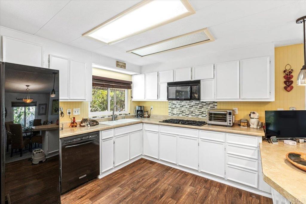 18218 Paradise Mountain Road, Unit 116 Valley Center, CA 92082 - Photo 5 of 35 a kitchen with a sink stove cabinets and refrigerator