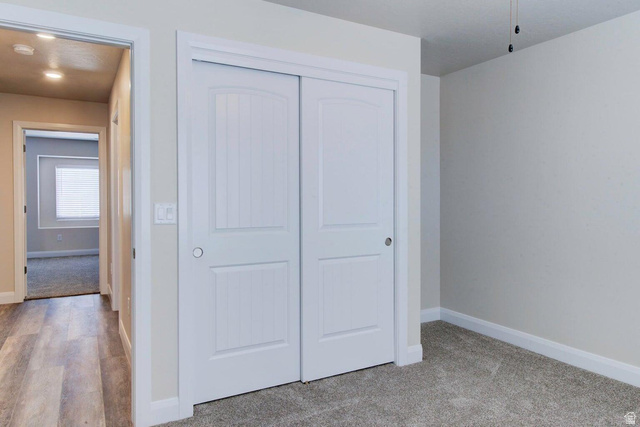 668 East Fiddlers Canyon Road, Unit 24 Cedar City, UT 84721 - Photo 9 of 21 Unfurnished bedroom featuring a closet and light colored carpet