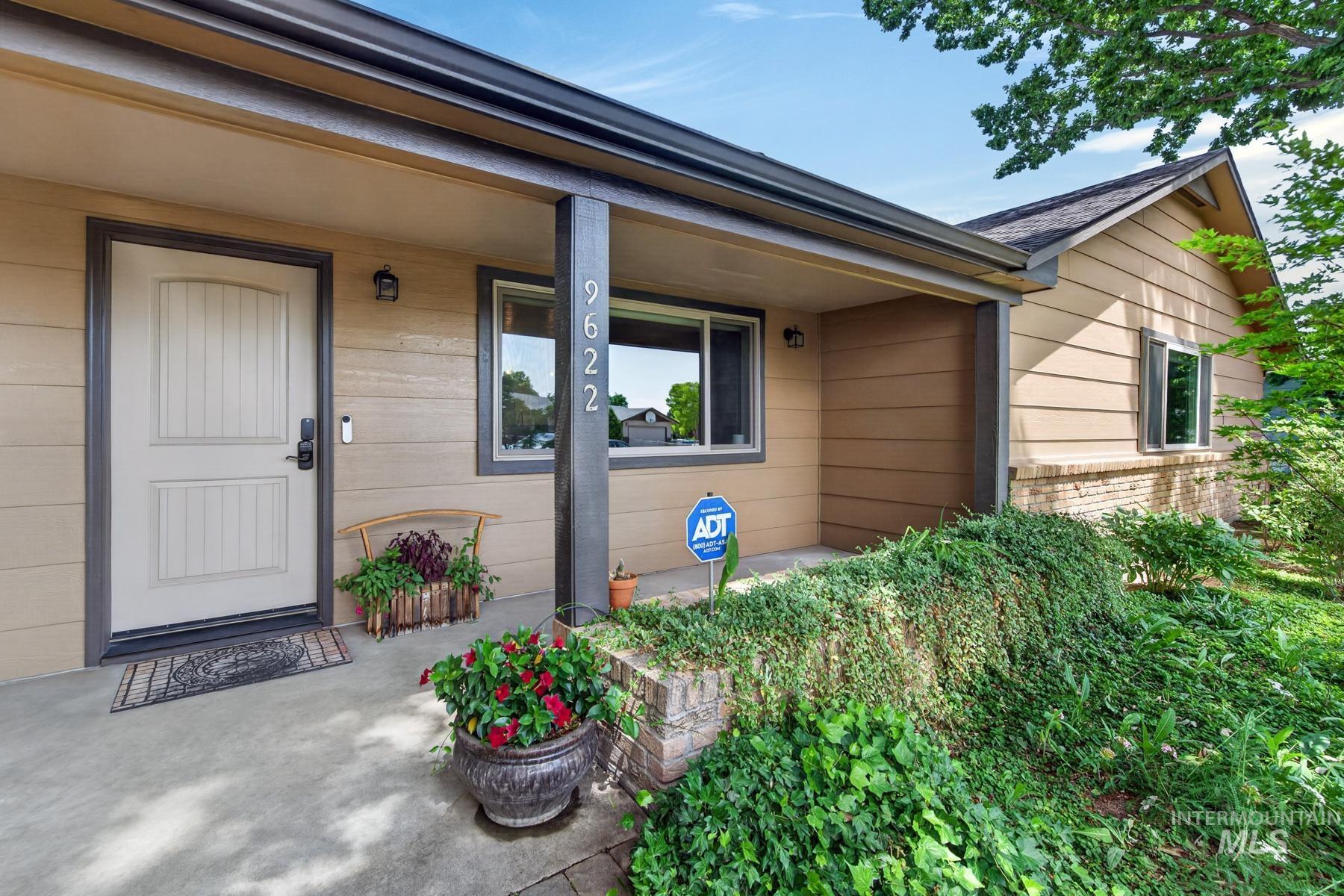 9622 Delaware Street Boise, ID 83709 - Photo 7 of 48 Covered front porch entry featuring a light-toned door with dark trim, contrasting siding, and a partial brick facade