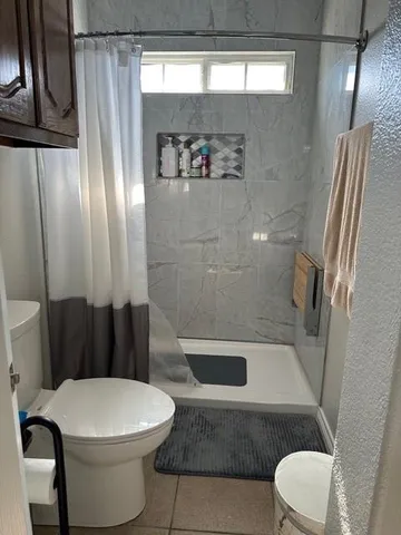 a bathroom with a toilet and a shower
