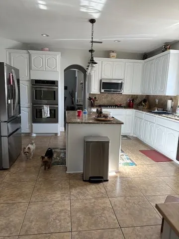 a kitchen with stainless steel appliances granite countertop a stove cabinets and a refrigerator