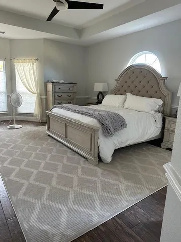 a bedroom with a bed a mirror and lamp