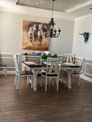 a view of a dining room with furniture wooden floor and a chandelier