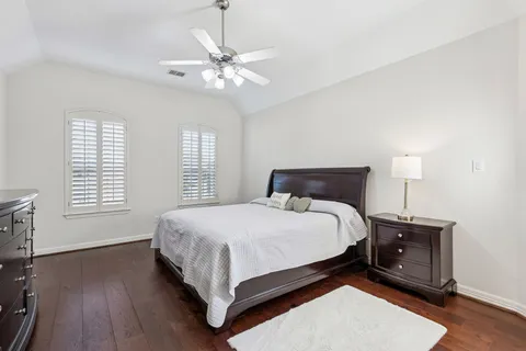 a large bed sitting in a bedroom next to a window and a chandelier