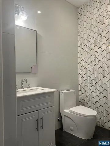 a bathroom with a toilet a sink and mirror
