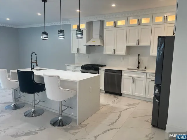 a kitchen with a sink a counter top space appliances and cabinets
